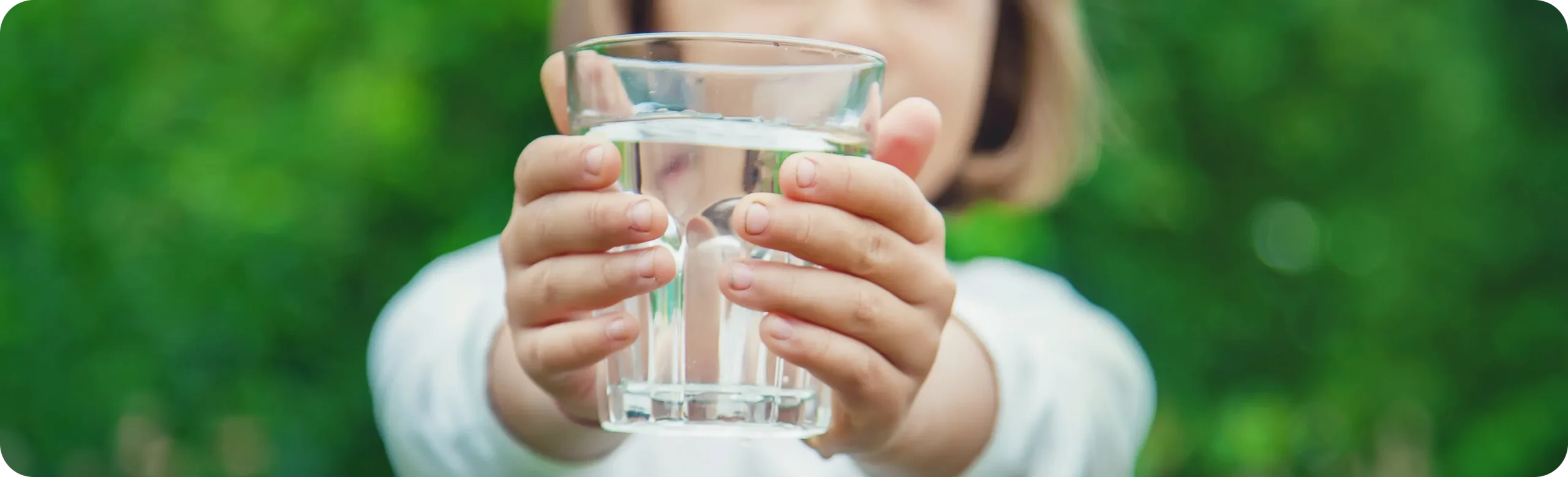 Child holding a glass of clean drinking water