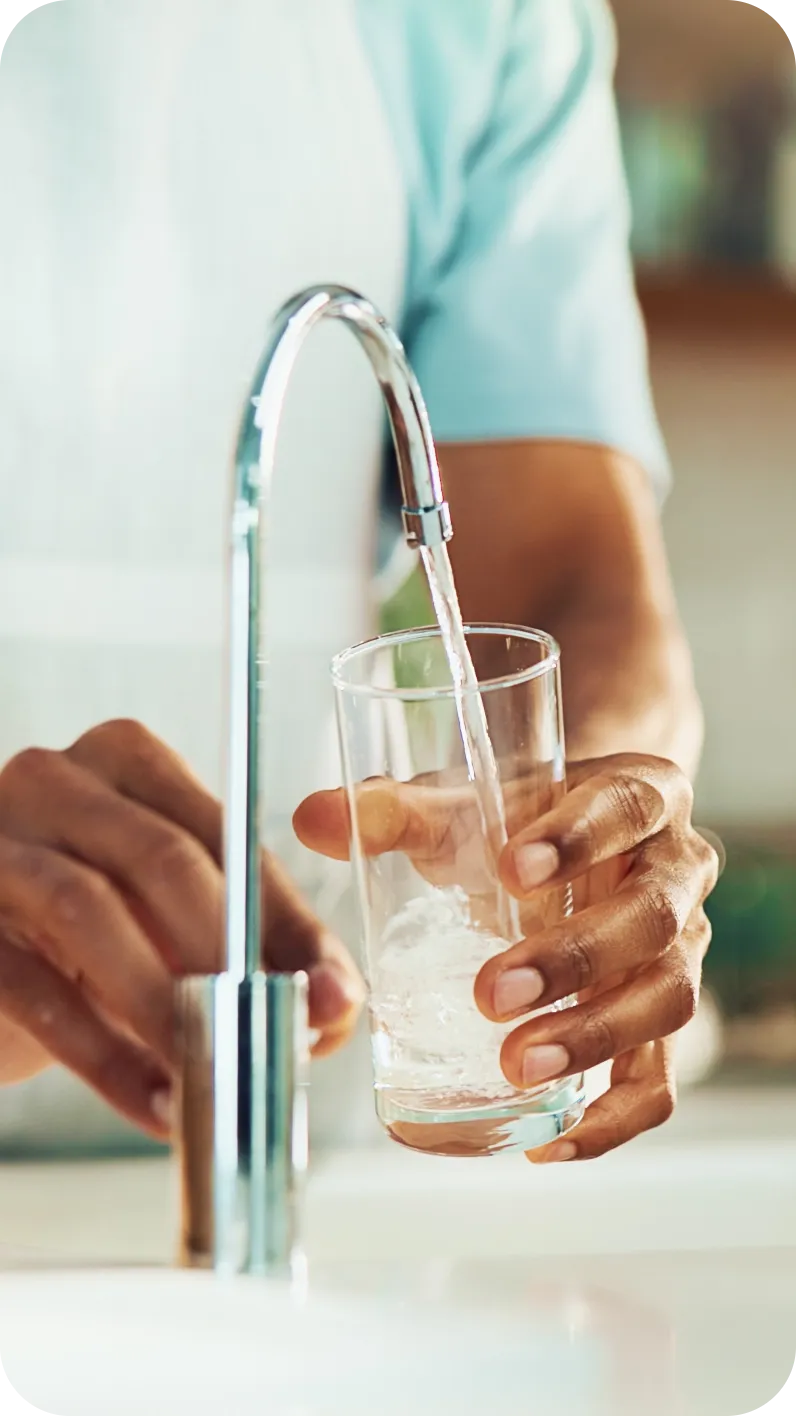 Hands holding a glass of clean water in the kitchen