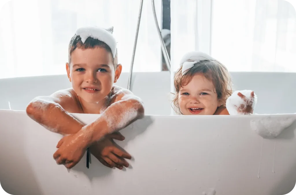 Two kids having fun washing their hands at the sink