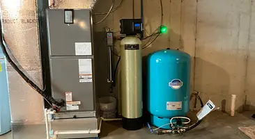 Cesare's whole-house water treatment system installed beside a well pressure tank in a Southwestern PA home