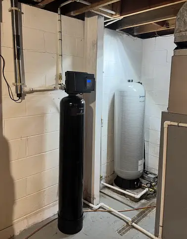 Whole-house water treatment system with media tank and brine tank installed in a Southwestern PA basement
