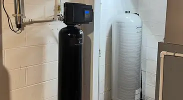 Water softener and filtration tanks installed in a basement by Cesare's