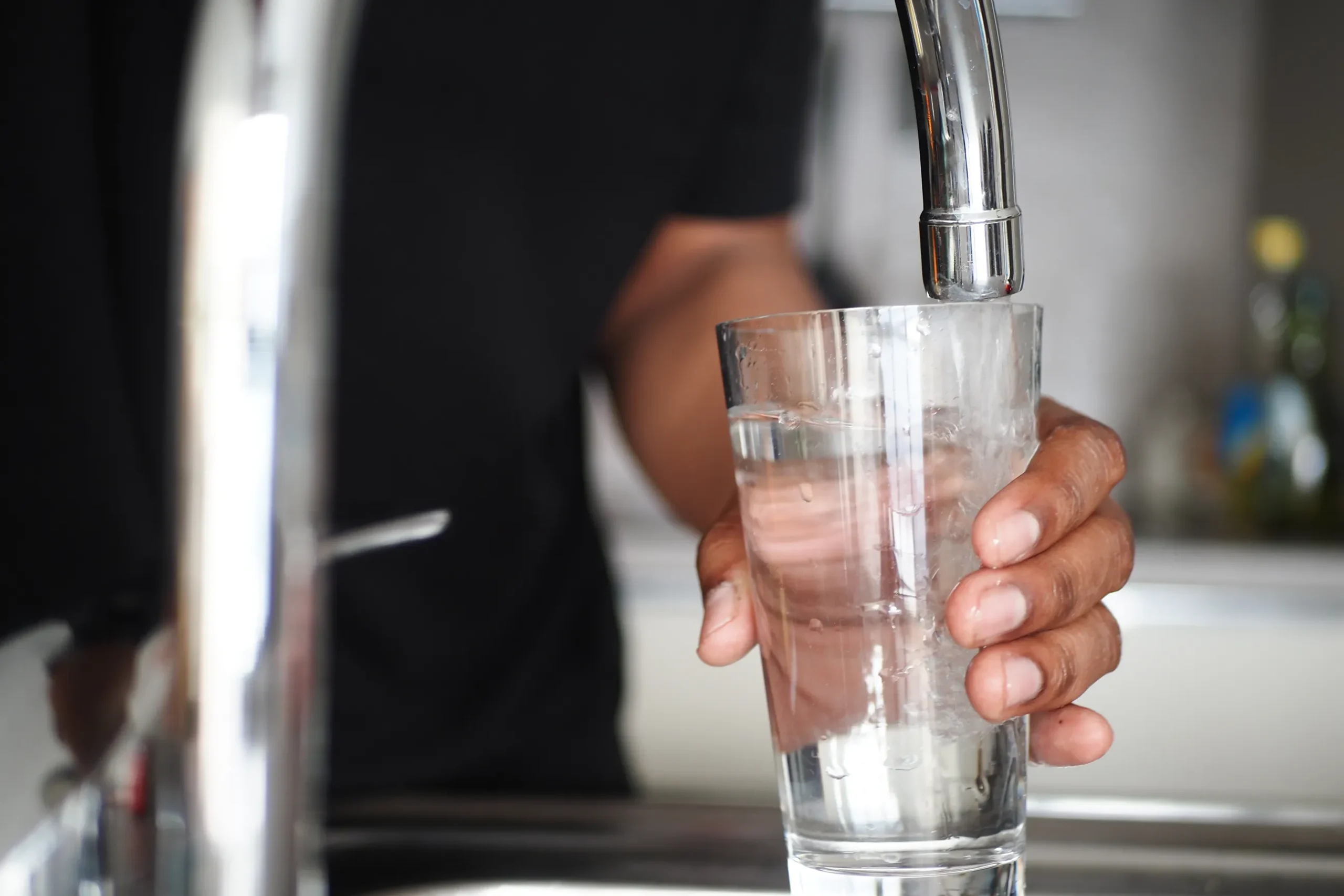 Holding a glass of dirty, discolored tap water