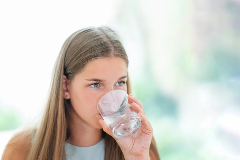 Teenager drinking a glass of city tap water at home in Southwestern Pennsylvania
