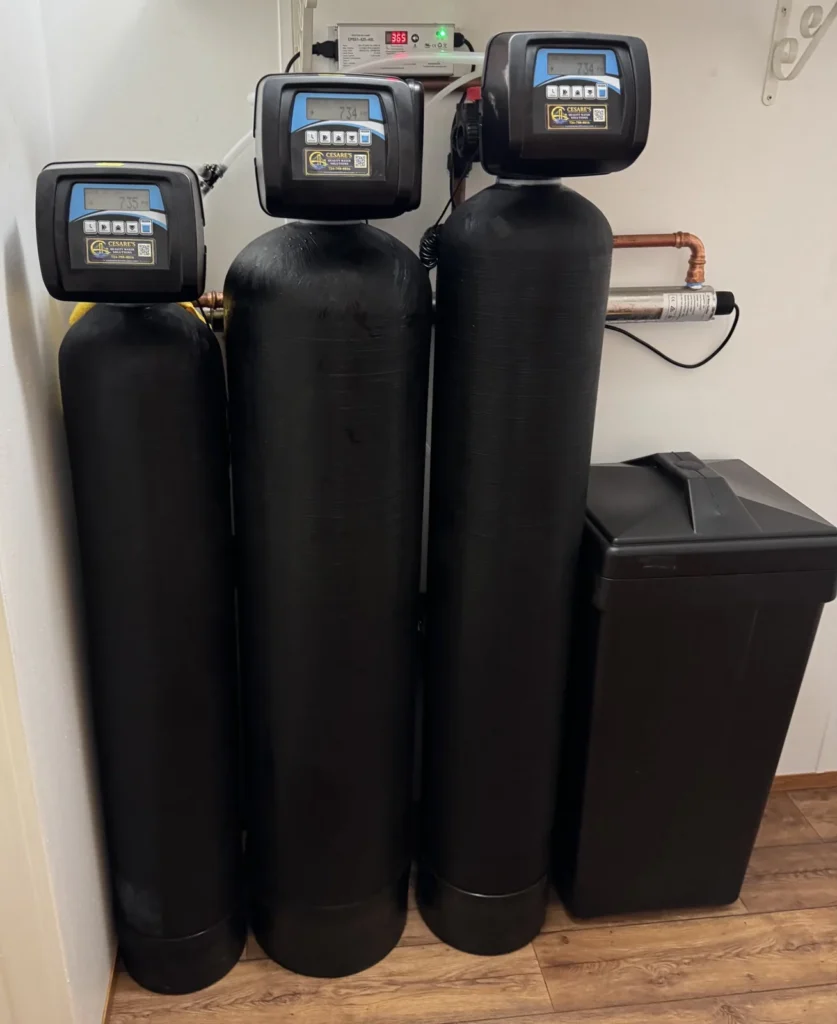 Cesare's three-tank whole-home water treatment system with UV disinfection and a brine tank on Cesare's control valves