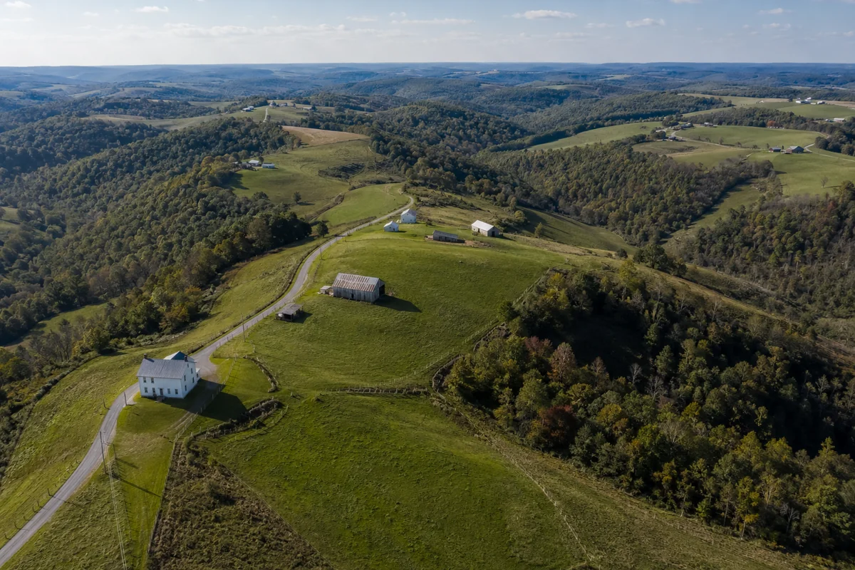 Aerial view of Amish farm country near New Wilmington in northern Lawrence County, Pennsylvania, with white farmhouses, grey barns and contour-striped fields