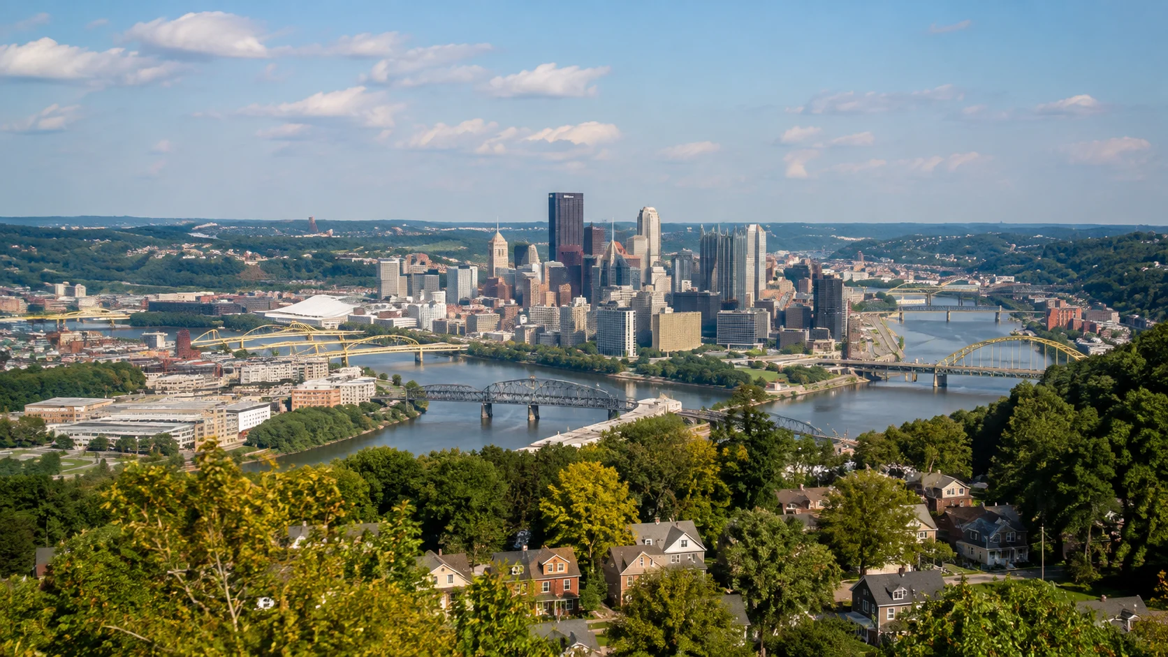 Panoramic view of Pittsburgh, Pennsylvania, with the downtown skyline, rivers, bridges and surrounding Allegheny County neighborhoods.