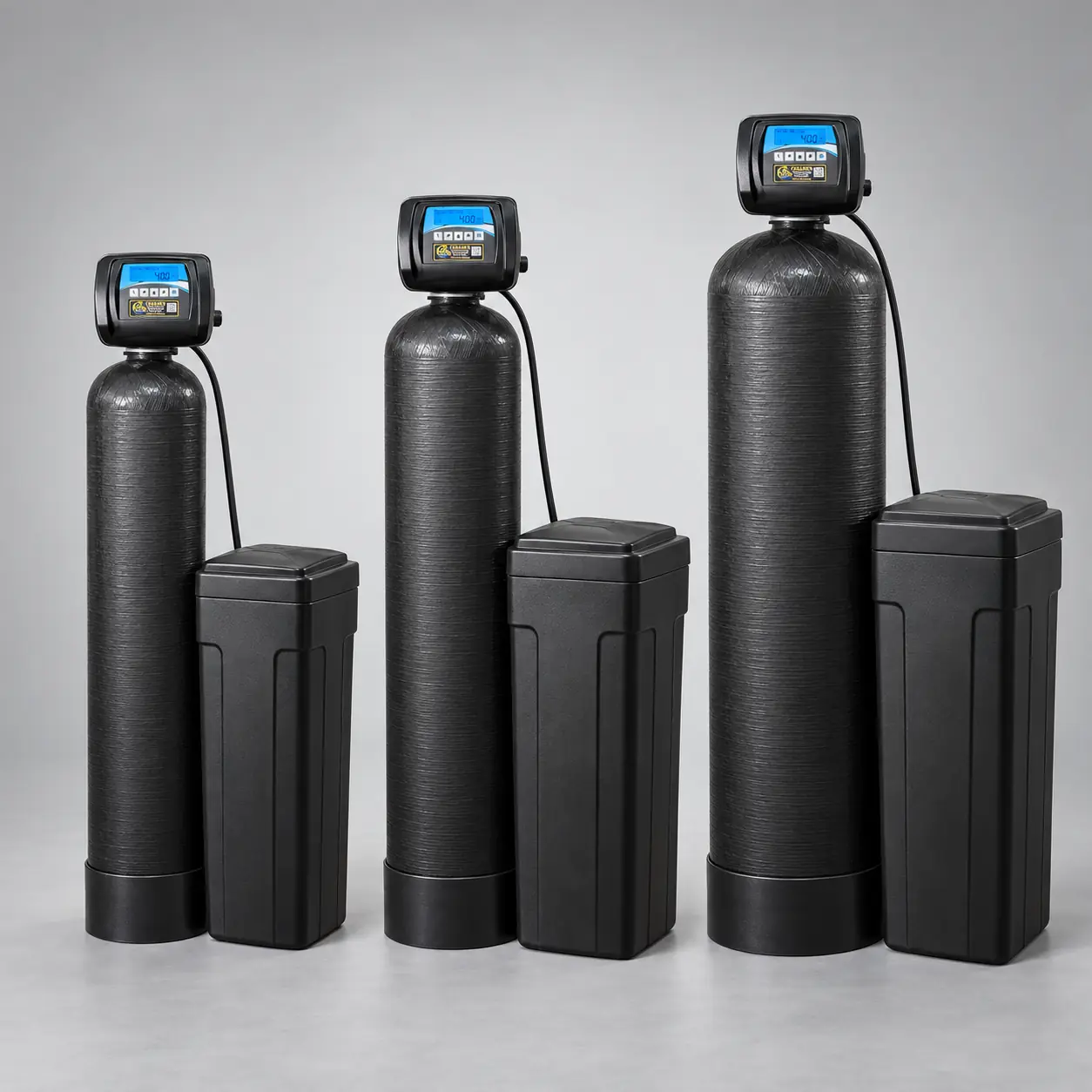 Three black water softeners arranged from smallest to largest, each with a digital control valve and matching brine tank.