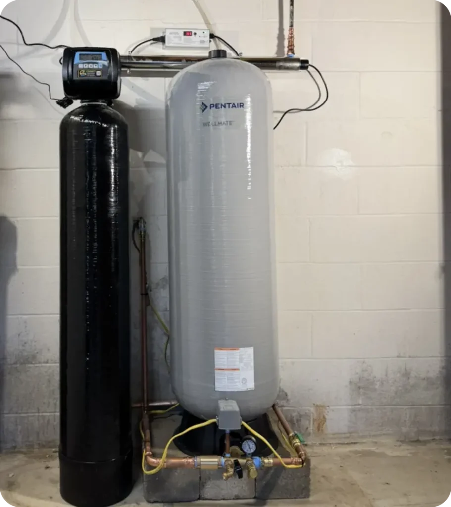 Whole-house well water treatment system with UV disinfection and a well pressure tank, installed by Cesare's Quality Water Solutions in a Southwestern PA basement.